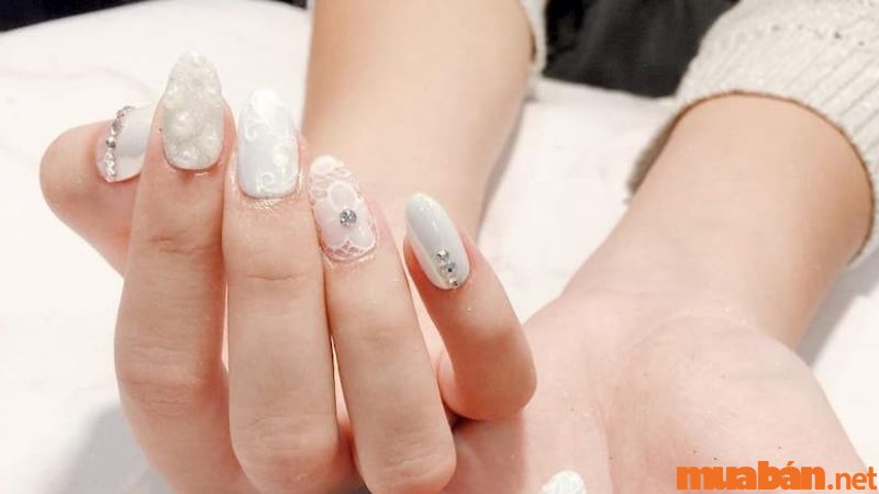 Mẫu nail cô dâu màu trắng điểm xuyết hoa và đá lấp lánh, thanh lịch (Nguồn: zicxa.com)