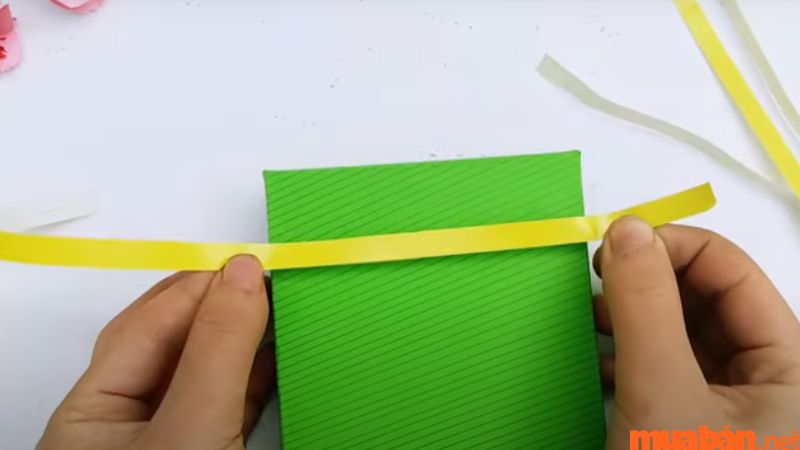 Dán giấy thành dây buộc để bánh chưng trông giống thật hơn