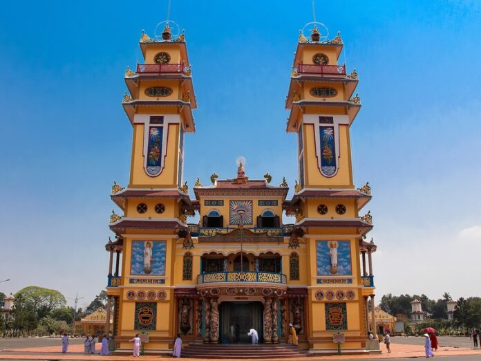 toa-thanh-cao-dai-tay-ninh Mặt tiền Tòa Thánh Cao Đài Tây Ninh với hai tháp vàng dưới trời xanh, nhiều người đứng trước sân