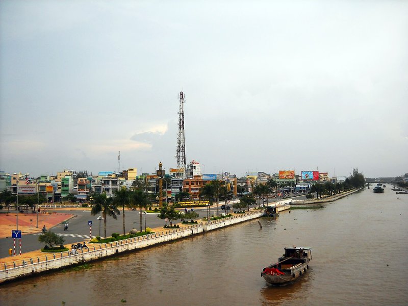 Bảng giá đất Cần Thơ 2026 mới nhất Trung tâm Vị Thanh nhìn từ trên cao, nhà phố ven kênh và một chiếc ghe